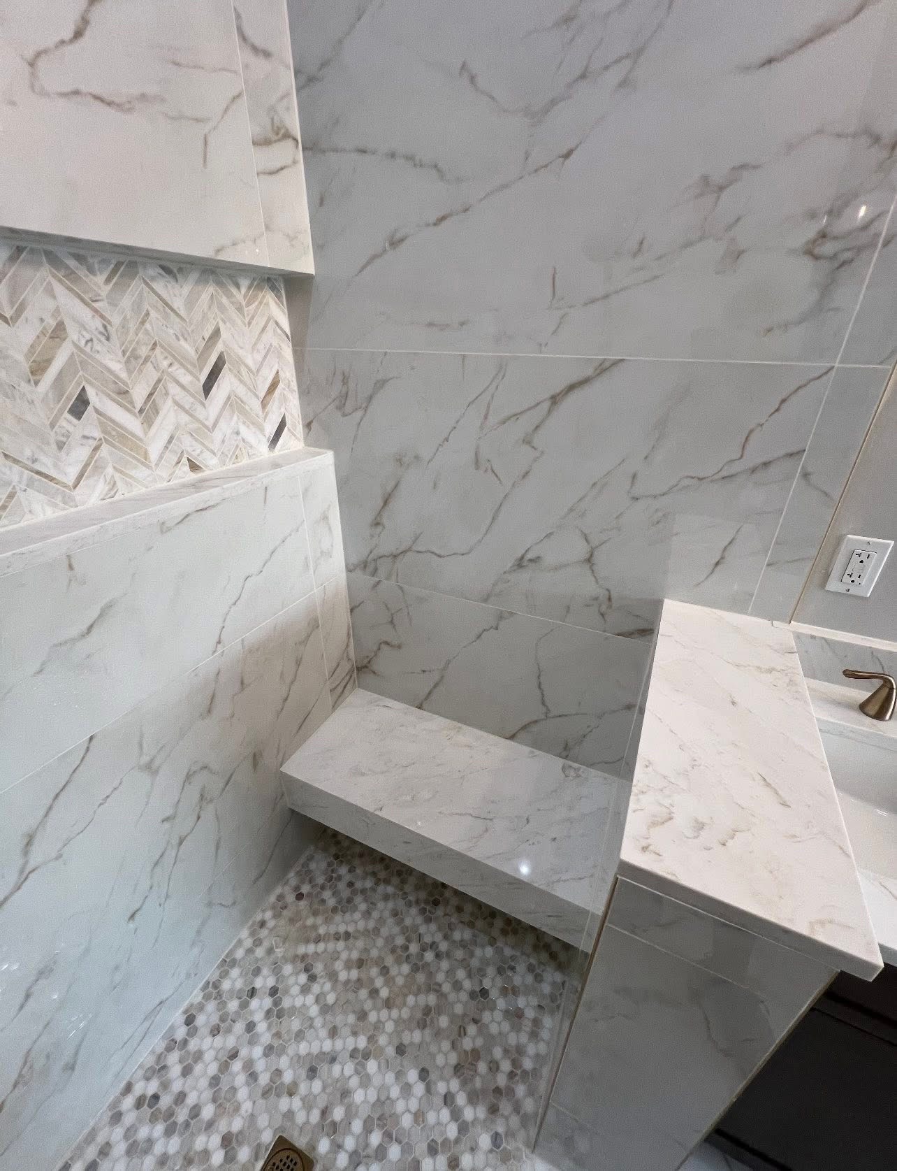 Calacatta marble shower with floating bench and penny tile floor