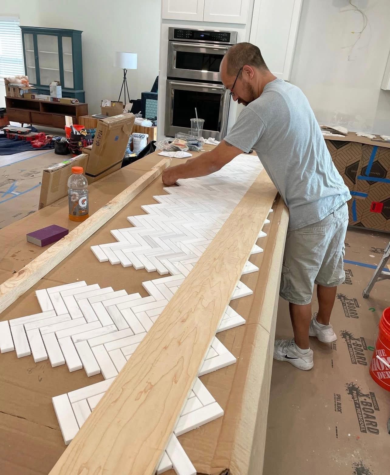 Herringbone marble tile work in progress on kitchen island