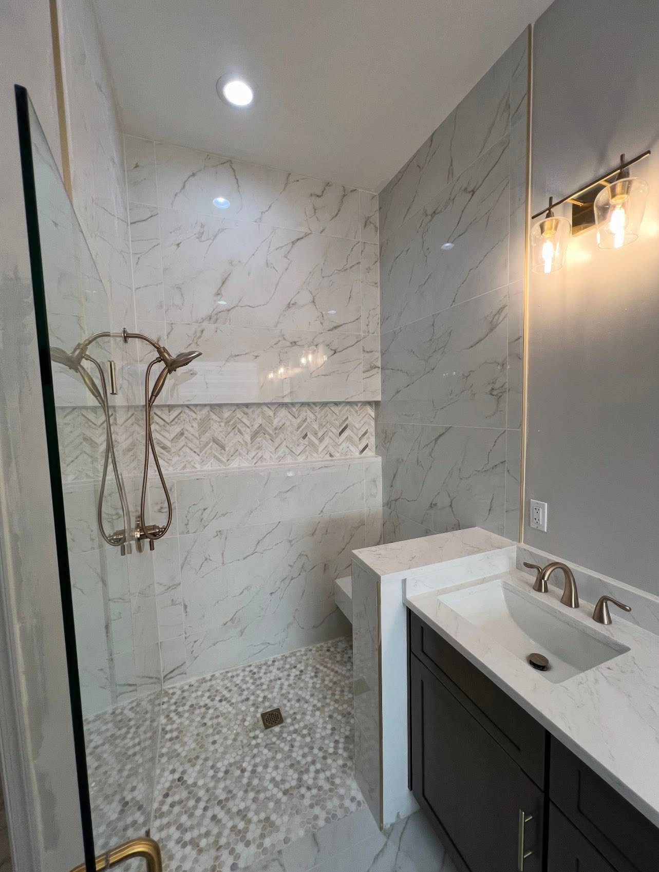 Marble bathroom with herringbone accent and brushed nickel fixtures